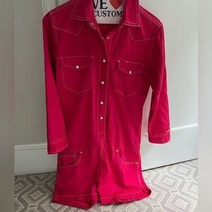Pink denim long sleeve romper with pocket and cross stitching. Never been worn.